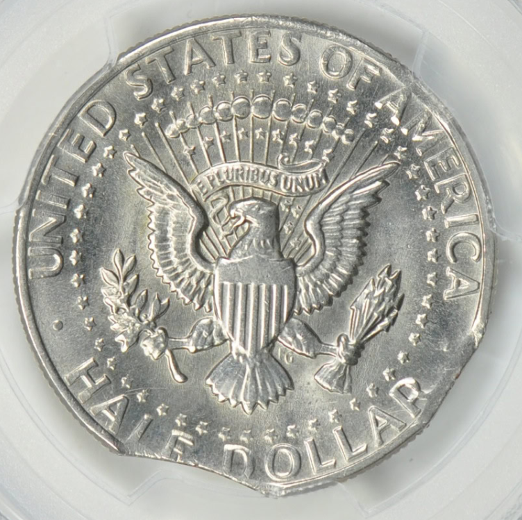 1989 Kennedy half dollar with curved clipped planchet error showing crescent-shaped missing section at coin edge and Blakesley effect on opposite rim